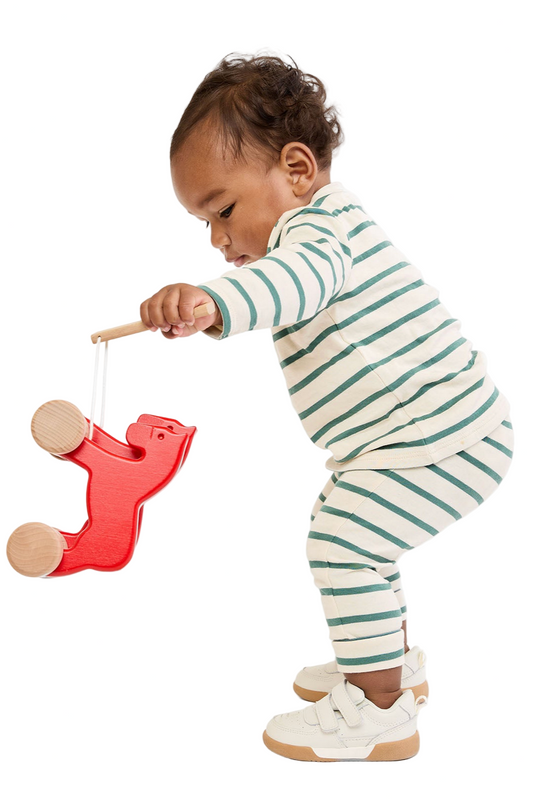 Child playing with a red toy on a white background