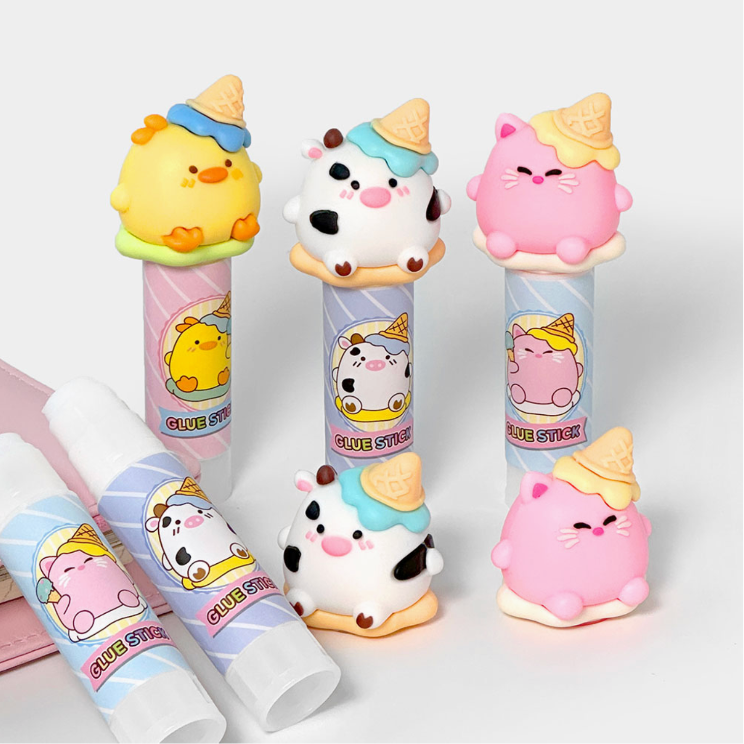 Set of cute animal-themed glue sticks on a white background