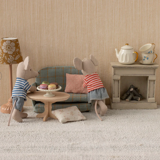Two toy mice in a living room setting with furniture and decor.